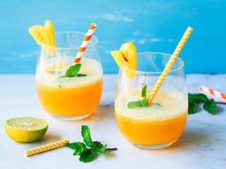 Pineapple juice in glass on blue background for healthy drink concept.