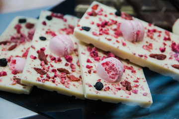 delicious dessert white chocolate bar decorated with pink chocolate ball and raisins, selective focus