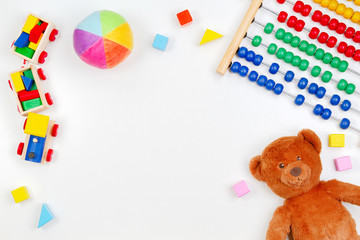 Baby kids toys background with teddy bear, wooden train,toy abacus and colorful blocks. Top view, flat lay