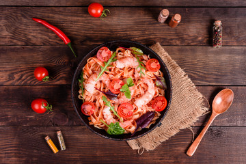 Plate, spoon, spices and other kitchen accessories on a dark wooden background