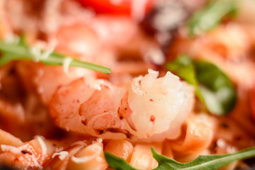Tasty pasta with shrimp and tomato on a frying pan
