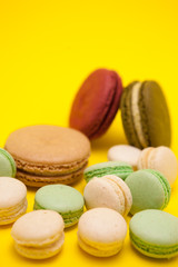 Tasty different macaroons flavour on yellow background