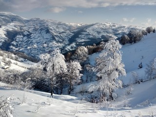 Fototapeta na wymiar Paisaje de invierno con montañas y nieve en Rumania, pueblo de Parva, Transilvania
