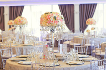 Tall white rose centerpieces at indoor wedding reception venue