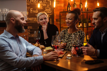 Group of friends having fun talk behind bar counter in a cafe