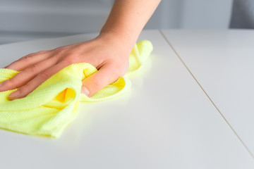 Girl wipes the table with a rag