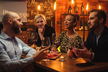 Group of friends having fun talk behind bar counter in a cafe
