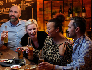 Group of friends watching tv in a cafe behind bar counter