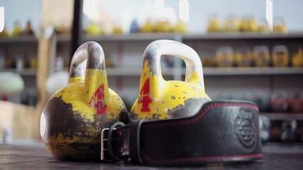 Two heavy kettlebell close-up, the athlete puts the athletic belt next.