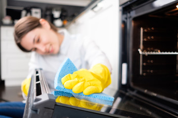 The girl washes the oven
