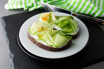 Cucumber sandwich. Healthy snack. Sandwich with cream cheese, cucumber, served on a plate. Symbolic image. Concept for a tasty and healthy meal. Close up.