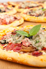assortment of ham, bacon, mushrooms and olives mini pizzas