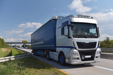 Fototapeta na wymiar LKW transportiert Güter auf der Straße - Logistik und Spedition // Trucks transport goods by road - logistics and freight forwarding 