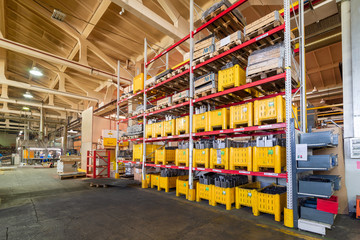 Factory warehouse steel reinforcement. large yellow plastic boxes on the shelves.