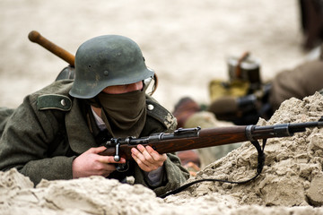 A German soldier in a trench with a rifle in his hand. Historical reenactment of the battle.