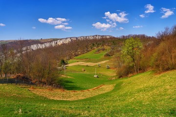 Fototapeta na wymiar Stunning mountain scenery in spring in Europe with many green hills and trees