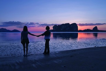 Fototapeta premium couple walking on the beach at sunset
