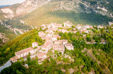 Fototapeta na wymiar aerial drone view of the small town Pierosara in the sibillini mountains surrounded by trees