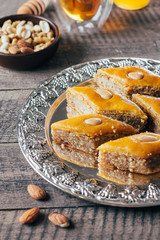 Baklava. Ramadan Dessert. Traditional Arabic dessert with nuts and honey, cup of tea on a wooden table background. Close-up