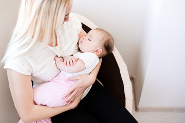 Baby girl sleeping on mother hands in room close up. Good morning.