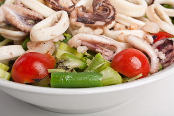 a bowl of seafood salad on a white background