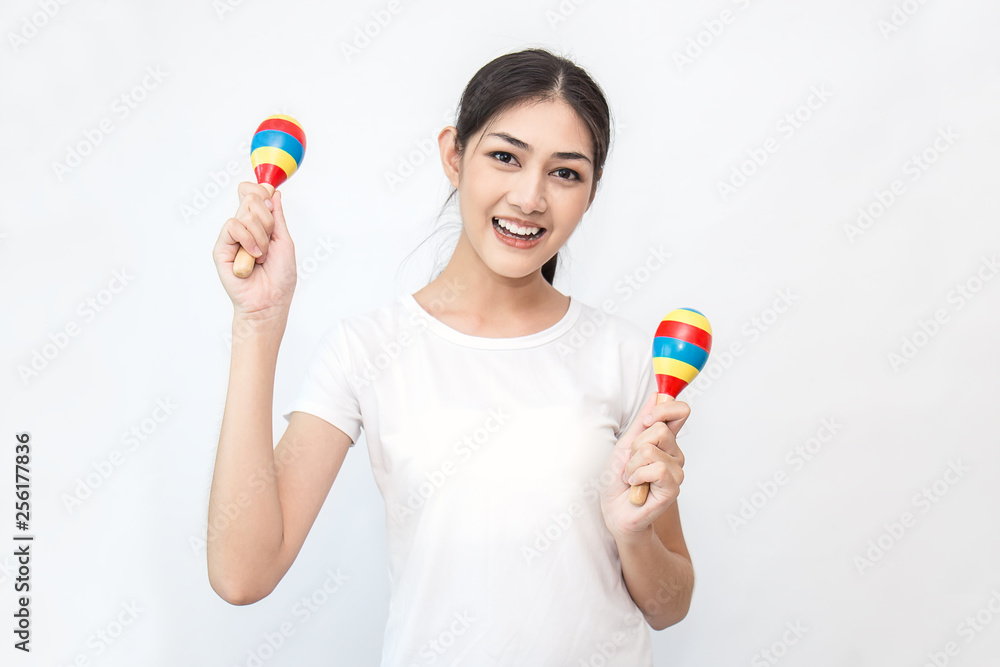 Wall mural Portrait of beautiful asian woman playing the maracas isolated on white background. Music song recreation relax lifestyle concept