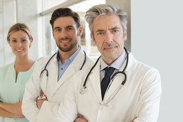 Team of doctors and nurse in hospital looking at camera