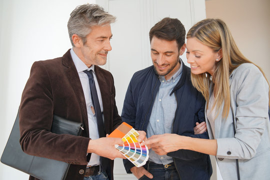 Real estate agent showing couple colour chart in contemporary home
