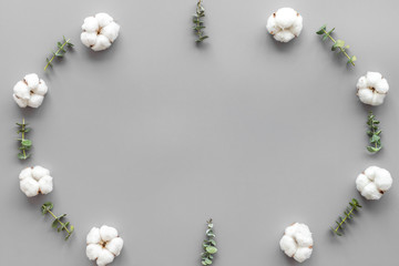 Flowers frame with fresh eucalyptus branches and cotton on grey background top view space for text