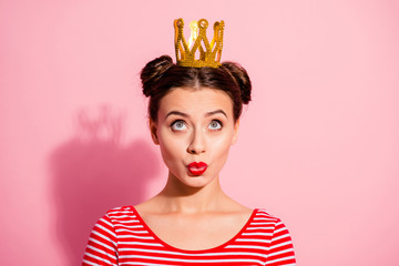 Close-up portrait of her she nice cute charming attractive lovely winsome fascinating cheerful cheery girl wearing striped t-shirt looking up gold diadem isolated over pink pastel background © deagreez