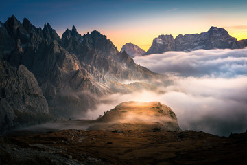 dramatic view of dolomites mountains above the clouds in the tre cime di lavaredo national park. foggy mountain landscape during sunset, South Tyrol.