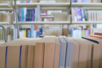 The old books in the library. Selective focus with blurred books in bookshelves background....
