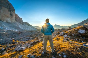 young man enjoying the view of the mountains landscape in the dolomites mountain range. tre cime di lavaredo national park, south tyrol