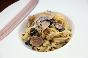 pasta with black truffles on wood background , Italian food