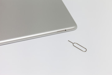 Silver inverted tablet. Visible tray for the SIM card and the key to open