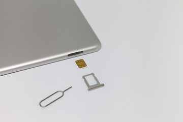 Silver inverted tablet. The SIM card tray is open.