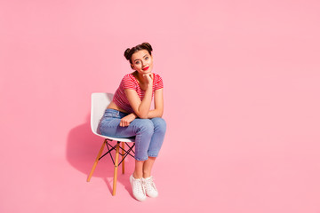 Fototapeta na wymiar Nice-looking attractive lovely glamorous adorable winsome lovely shine teen girl wearing striped tshirt jeans sitting on chair resting having spare day time isolated over pink pastel background