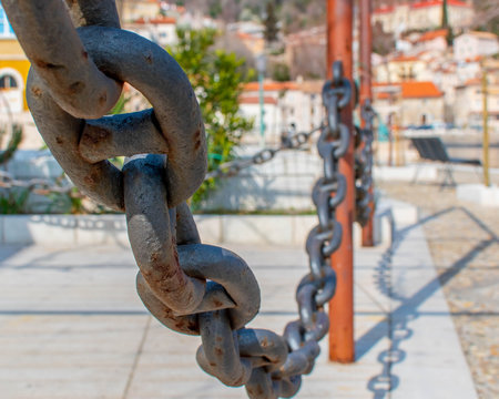 Chains at front and old town at background with shadow of chains at street.