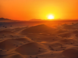 Fototapeta na wymiar Red sand mountains and sun in sahara desert
