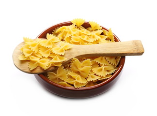 Farfalle pasta pile in bowl with wooden spoon isolated on white background