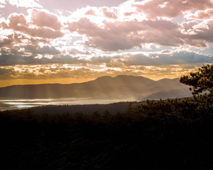 Sunset at Rijeka Croatia with reflections at sea and clouds above.