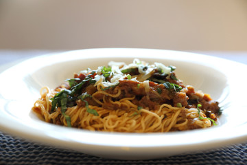 spaghetti Bolognese with minced beef and tomato sauce garnished with parmesan cheese and basil , Italian food