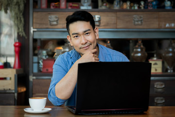 Asian man in deep thought closeup in profile with laptop.