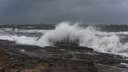 Splash of huge waves on a rocky shore