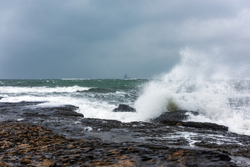 Fototapeta na wymiar Splash of huge waves on a rocky shore