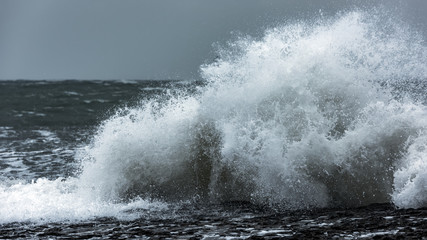 Splash of huge waves on a rocky shore