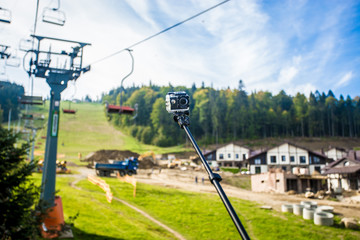 action camera on selfie stick on peak of mountains