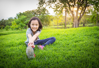 Naklejka na ściany i meble Asian little girl exercising at the outdoor park on the lawn is a meditation practice,child exercise in nature in the morning,healthy lifestyle concept