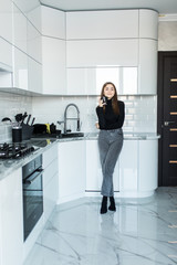 Young happy woman drinking coffee on the kitchen in the morning.