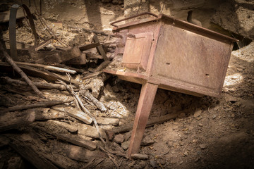 Sunlight on an old antique rusted stove found between the remainings of a wooden barrel in a abandoned house in Kato Chora, Kythira, Greece